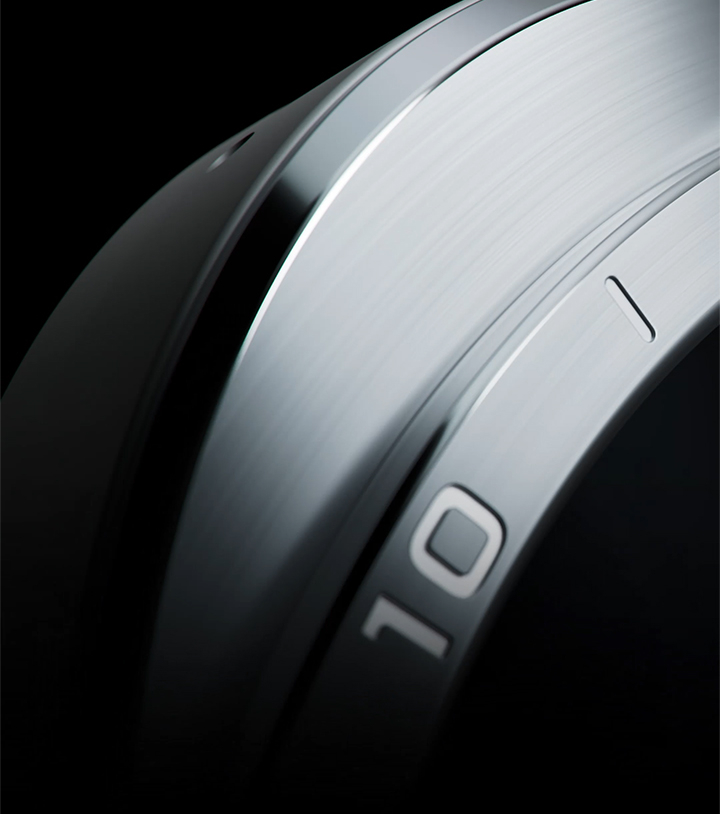 Close-up view of the elegant silhouette of a Galaxy Watch Ultra2 in Titanium Silver with its sculpted edges and bezel shown in detail from different angles. The view zooms out to show the overall design of a Galaxy Watch Ultra2 in Titanium Silver with a Marine Band in Olive facing forward.