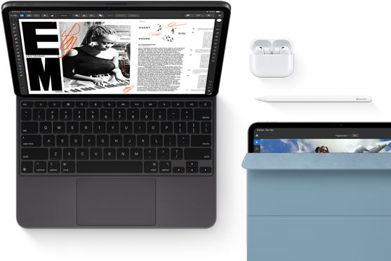 iPad Pro attached to Magic Keyboard, front exterior, space black colour, rounded corners, black display bezel, open, display showing article editing app with text and photograph of a woman playing music, AirPods 4 in open case, blue Smart Folio cover on iPad Pro with Apple Pencil Pro resting atop device, cover slightly open revealing display