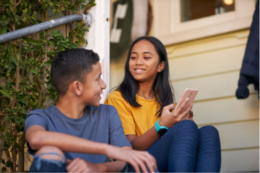 Two kids sitting together on the phone